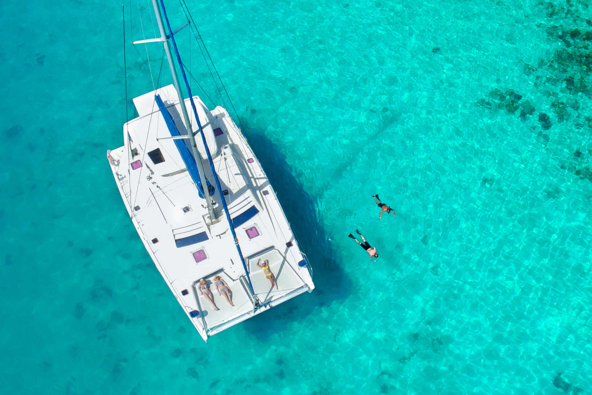 katamaran auf mallorca segelreise mit Paar am schnorcheln im kristallklarem Wasser